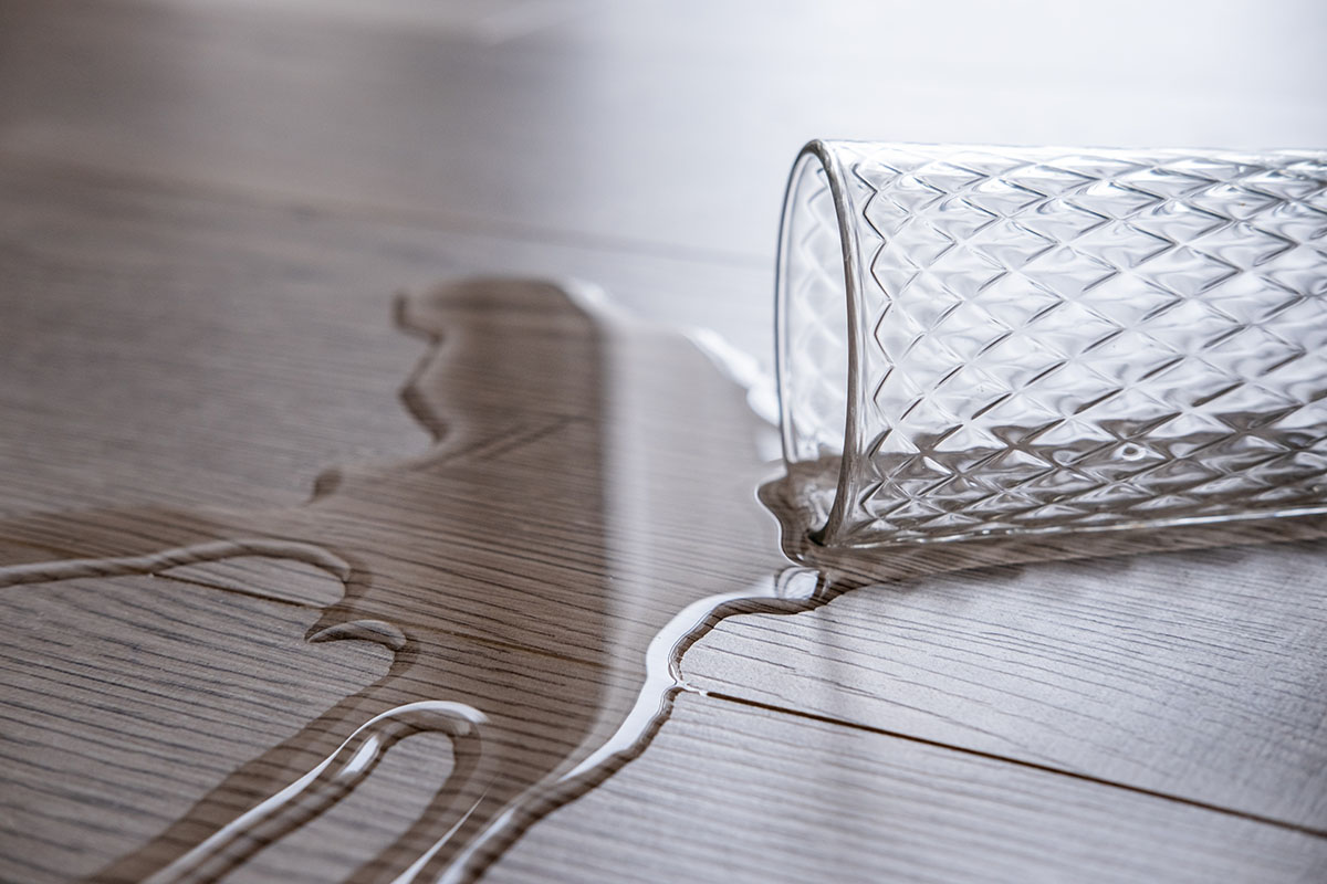 Glass of water spilled on floor | Leon Country Floors & More